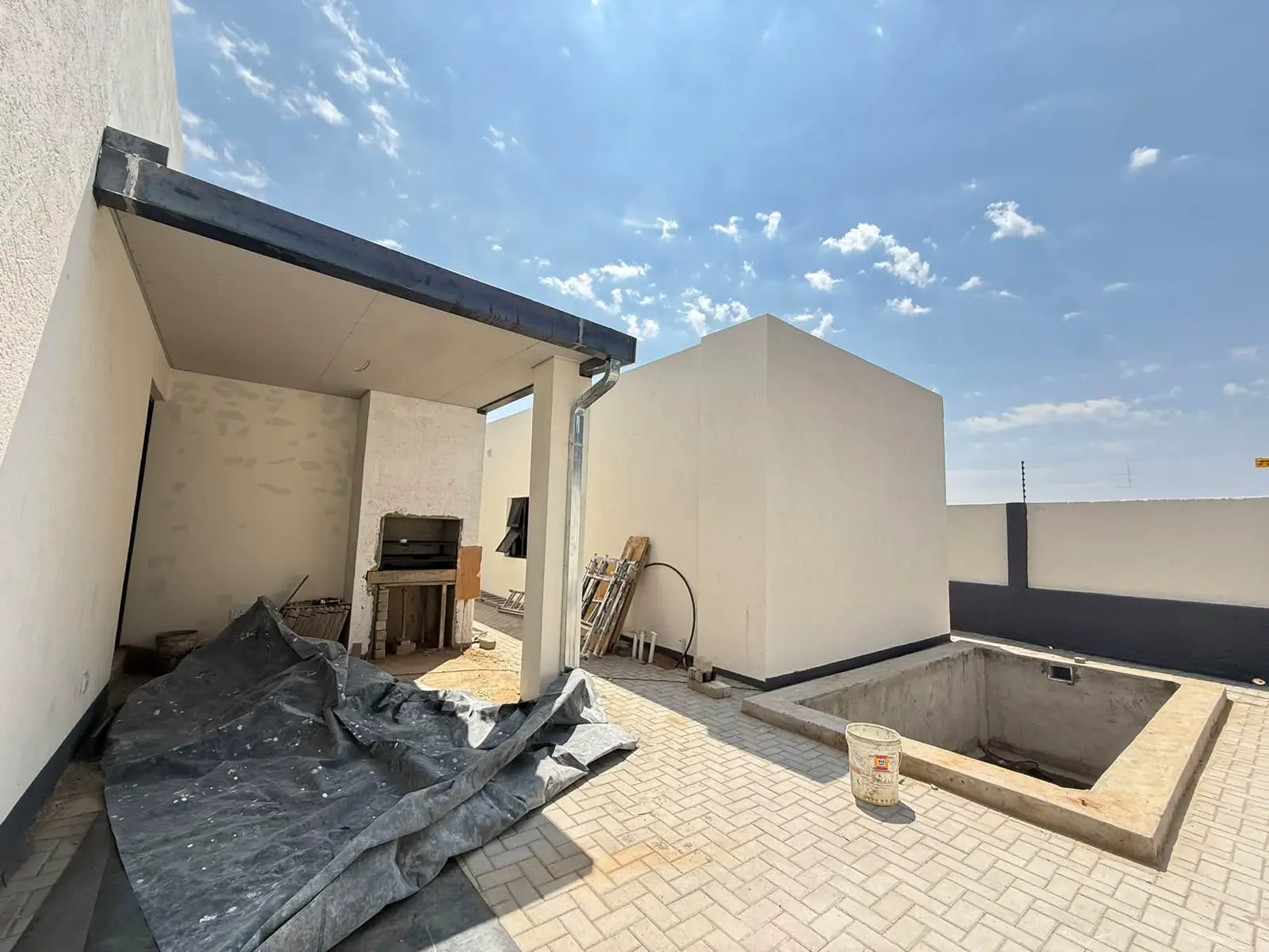 Outside: Entertainment area, with the pool being built